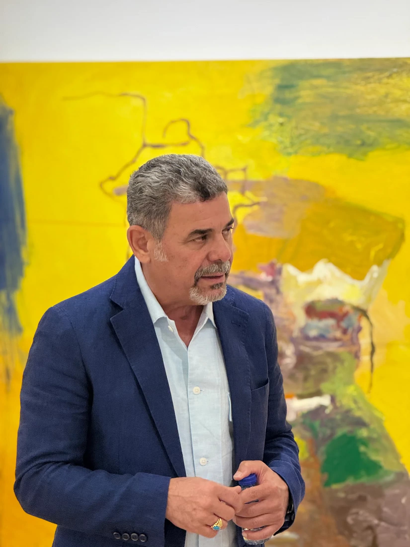 The artist in conversation beside the yellow canvas.