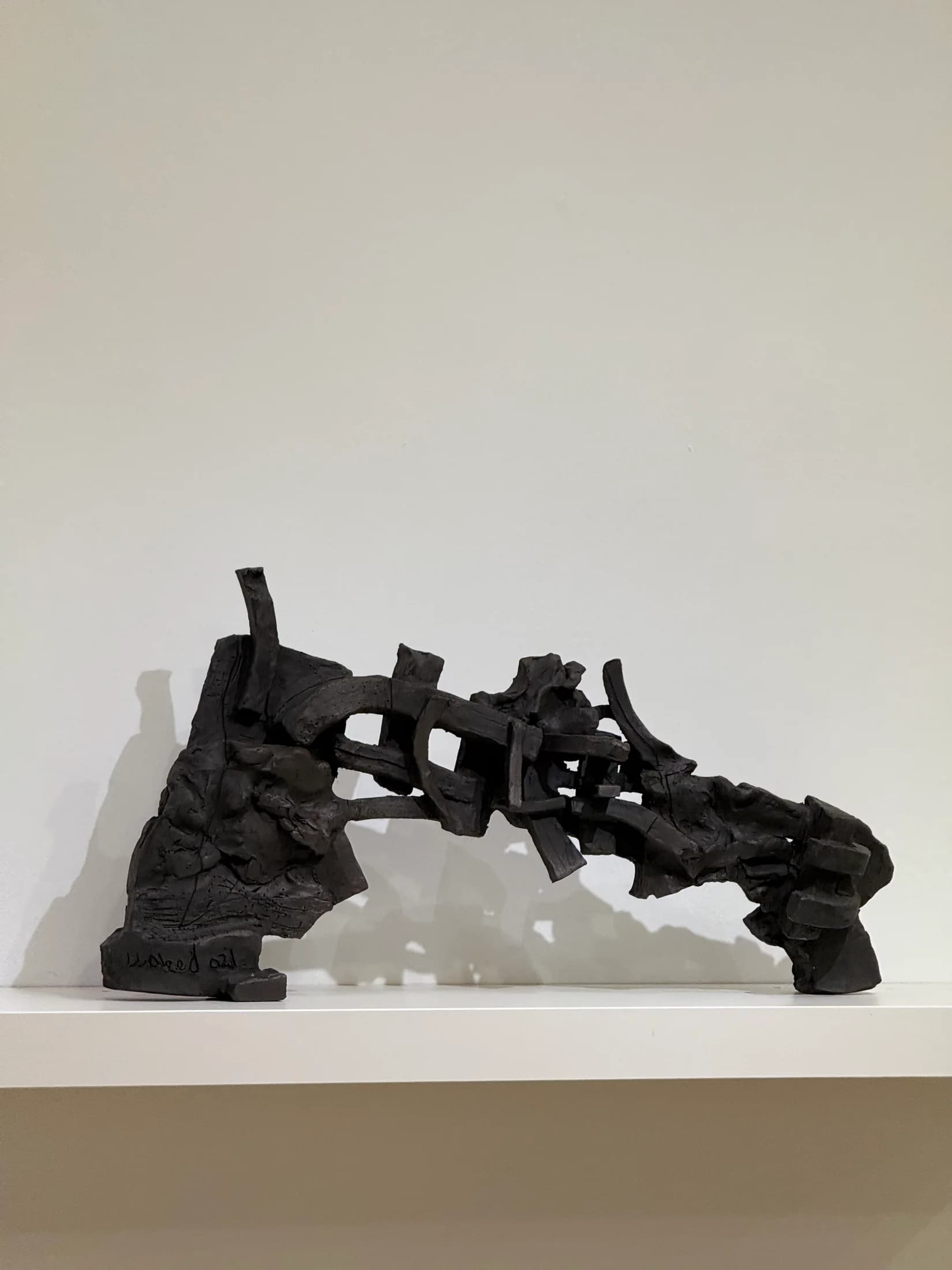 Blackened construction: interlocking beams that never quite become a chair.
